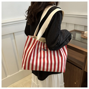 Détail du grand sac cabas en toile à rayures rouges et blanches avec larges bandoulières