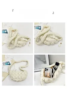Detailed interior storage view of a white quilted crescent bag with pearl chain strap