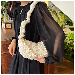 Detail of quilted cloud bag with pearl chain and pleated shoulder strap in cream white