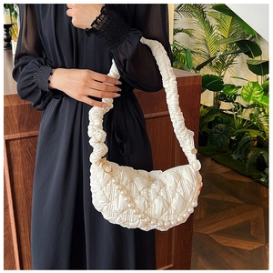 Close-up of white quilted cloud bag featuring a ruched strap and elegant pearl chain