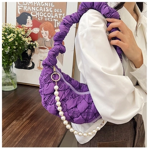 Detail view of the purple quilted cloud bag with puffy texture and elegant pearl strap