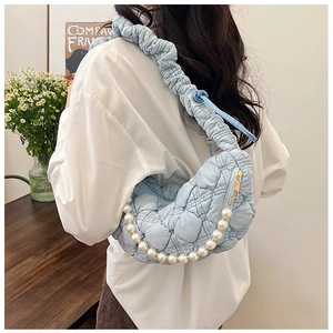 Detail view of light blue pleated cloud bag featuring soft texture and pearl chain strap