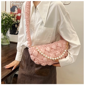 Detail of pink pleated crescent bag with pearl chain strap and ruffled shoulder design