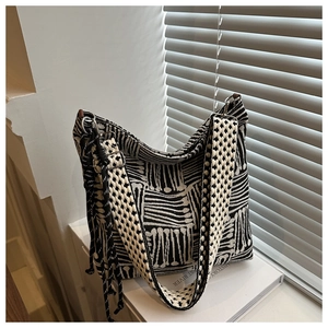 Dettaglio di borsa tote in tela con motivo geometrico astratto in bianco e nero