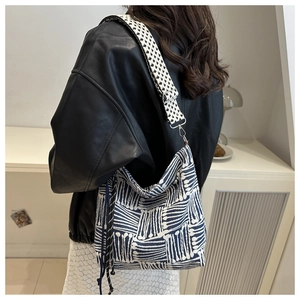 Detail of blue and white woven tote bag with floral pattern wide shoulder strap