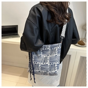 Blue and white striped canvas tote with geometric wide strap shown in an office setting