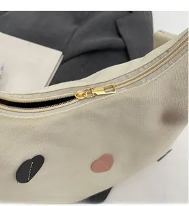 Detail of smooth metal zipper and colorful heart patches on the canvas tote bag