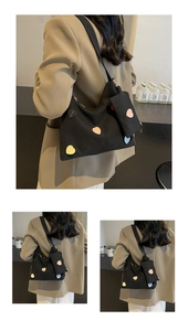 Detail of black canvas tote bag with colorful heart patches and matching small coin purse