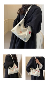 Detail of white canvas hobo bag with colorful heart patches and matching mini pouch