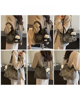 Detail view of large dark grey stone texture tote bag with plush cloud pendant accessory