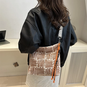 Borsa a spalla in tela a righe con tracolla a scacchi mostrata su modella in stile