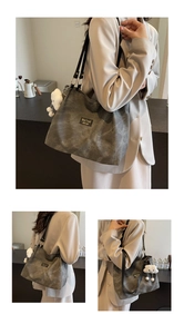 Detail view of large grey canvas tote bag with leather strap and plush charm