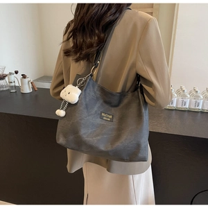 Detail of dark grey tote bag with soft texture and white cloud plush charm pendant