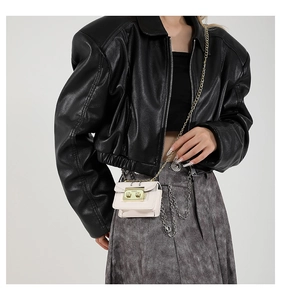 Gros plan d'un mini sac bandoulière en cuir rose avec chaîne dorée sur un mannequin