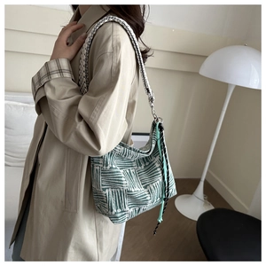 Detail of green and white geometric woven fabric texture on tote bag with wide strap