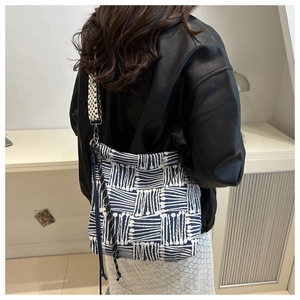 Detail of high-density jacquard tote bag with geometric lines and wide patterned strap
