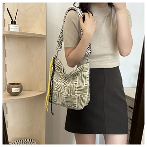 Detail of canvas tote bag with olive green stripes and polka dot wide shoulder strap