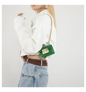 Gros plan d'un mini sac à rabat en cuir vert avec boucle dorée et bandoulière chaîne