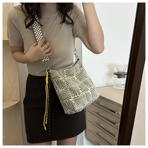Close-up of wide houndstooth strap and green geometric pattern on canvas tote bag