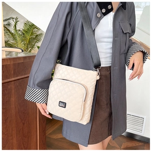 Detail of beige quilted shoulder bag with zipper pocket and wide fabric strap