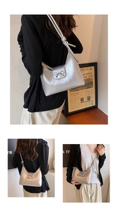 Silver metallic leather hobo bag featuring a decorative bow and knotted shoulder strap