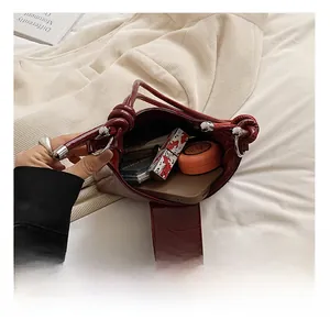 Interior view of the burgundy tote bag showing capacity for phone, lipstick and powder