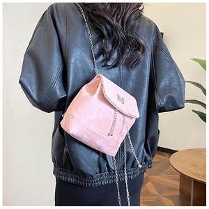 Close-up of pink mini crossbody bag with silver butterfly and metallic tassels
