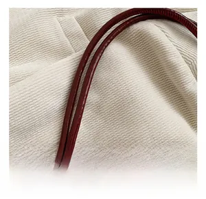 Detail of red faux lizard embossed leather handle with knot design and glossy finish