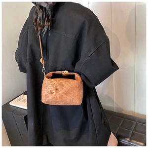 Detail of brown woven texture on casual crossbody bag with gold metal hardware