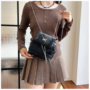 Detail of black velvet mini backpack with silver butterfly buckle and chain strap