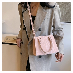 Detail of pink glossy pleated texture on rectangular handbag with smooth finish