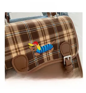 Close-up of British style brown plaid fabric bag with exquisite cartoon animal embroidery