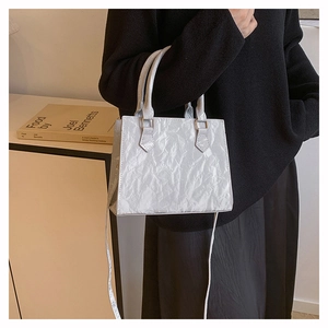 Detail of silver PU leather crossbody bag featuring unique crinkled foil texture and strap