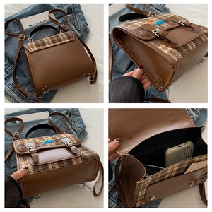 Detail view of British style brown patchwork backpack with plaid texture and embroidery