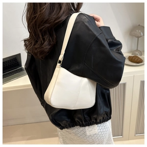 Minimalist white leather underarm bag shown with a black leather jacket and lace skirt