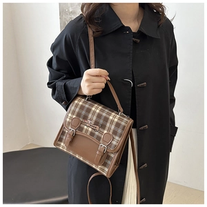 Detail of retro plaid bag featuring a cartoon dachshund embroidery and dual leather straps