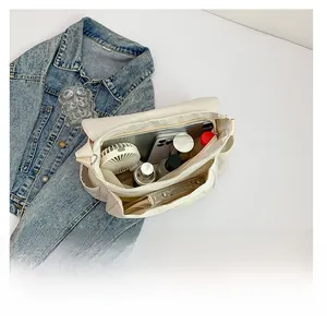 Detail view of white messenger bag interior showing spacious capacity and multi-pocket storage