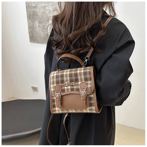 Detail of vintage plaid backpack with dachshund embroidery and brown faux leather trim