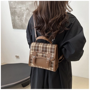 Detail view of vintage brown plaid backpack featuring a cute dachshund embroidery patch