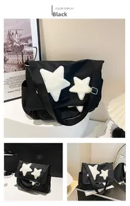 Detail of black canvas messenger bag featuring white plush star patches and wide strap