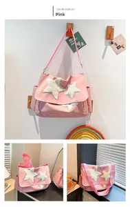 Detail of pink canvas tote bag with white plush stars and adjustable shoulder strap