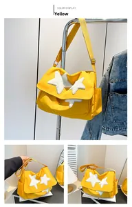 Detail of yellow messenger bag featuring white plush star patches and adjustable strap