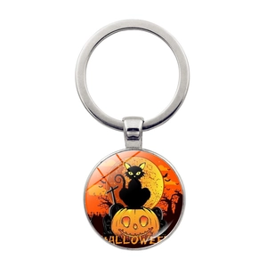 Detail eines Halloween-Schlüsselanhängers mit schwarzer Katze auf Kürbis und Vollmond