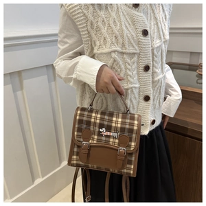 Detail of vintage brown plaid handbag featuring a cute dachshund embroidery and metal handle