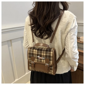 Detail of vintage plaid mini backpack with leather trim and dachshund embroidery on back