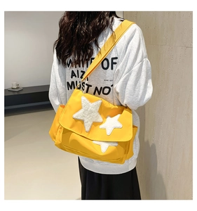 Detail of yellow canvas star messenger bag showing size and fit on model back