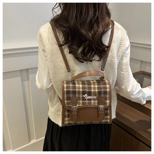 Detail of vintage plaid mini backpack featuring a cute dachshund embroidery and metal buckles