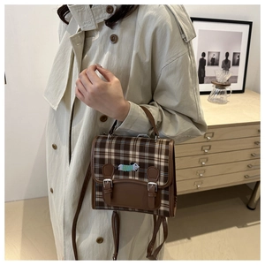 Detail of vintage brown plaid crossbody bag with cute dachshund embroidery and leather trim