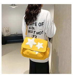 Detailed back view of bright yellow star tote bag with white plush stars and wide strap