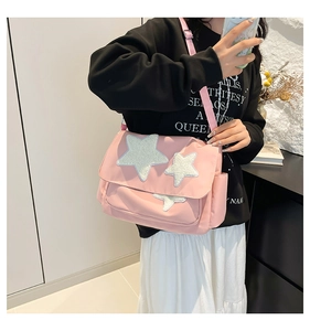 Side view of pink canvas crossbody star bag with adjustable strap worn by model
